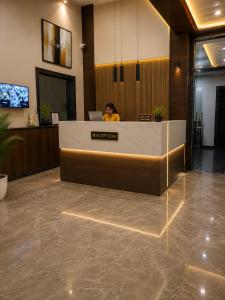 a woman sitting at a reception desk in a lobby at Hotel Starlin Near Delhi Airport & Free Airport pickup in New Delhi