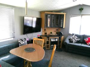 a living room with a table and a couch at Bermuda The Chase Ingoldmells Central Heated FREE WIFI in Ingoldmells