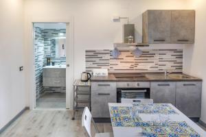a kitchen with a sink and a stove top oven at La Fenice Suites Sardinia in Quartu SantʼElena