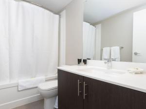 a white bathroom with a sink and a toilet at Hendrix Luxury Apartments by Corporate Stays in Edmonton +46 photos