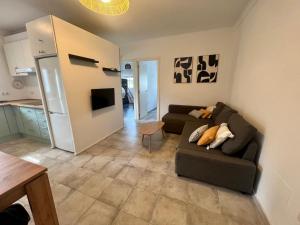 a living room with a couch and a kitchen at Casa Playa La Barrosa in Novo Sancti Petri