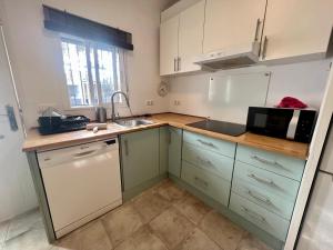 a small kitchen with a microwave and a sink at Casa Playa La Barrosa in Novo Sancti Petri