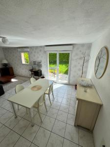 a living room with a table and chairs and a clock at Maison 3 chambres in Morlaix
