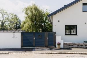 a blue gate in front of a white house at Studio Bachgeflüster in Schattendorf
