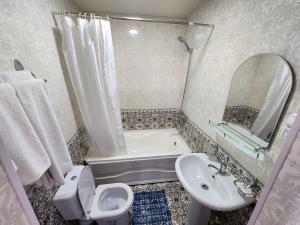 a bathroom with a sink and a toilet and a bath tub at Khiva Siyovush Hotel in Khiva