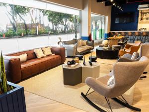 a large living room with couches and chairs at Ibis Styles El Malecon Guayaquil in Guayaquil