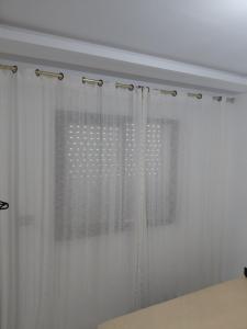 a window with white curtains in a room at La perle in Sukrah