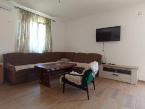 a living room with a couch and a table and a tv at Latina lastva in Budva