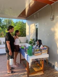 a group of people standing around a table with books at Tiba Meka Homestay in Komodo Labuan Bajo Airport