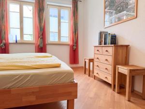a bedroom with a bed and a dresser and windows at Ferienwohnung Binder - Ferienwohnung Bad Windsheim in Bad Windsheim