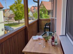a wooden table on a balcony with wine bottles and glasses at Ferienwohnung Binder - Ferienwohnung Bad Windsheim in Bad Windsheim