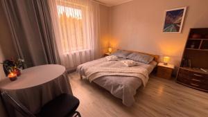 a bedroom with a bed and a table in it at Ēmužas in Dārte