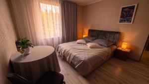 a bedroom with a bed and a table and a window at Ēmužas in Dārte