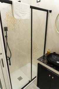 a shower with a glass door in a bathroom at Na Suite QuartieriSpagnoli in Naples