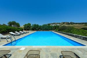 a large swimming pool with lounge chairs next to it at Aurora by Mediterra in Isterni