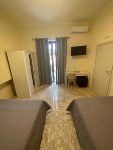 a room with two beds and a desk and a television at B&B Dosti in Scafa +12 photos
