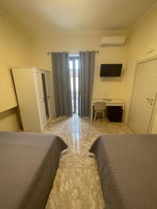 a hotel room with two beds and a desk and a window at B&B Dosti in Scafa