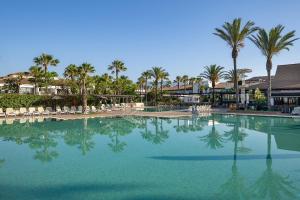 a large swimming pool with palm trees and chairs at Impressive Playa Granada Golf in Motril