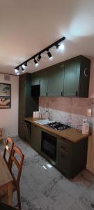 a kitchen with green cabinets and a stove top oven at Apartament Sobieskiego in Puck