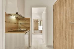 a kitchen with a sink and a wooden cabinet at Jimmy's by the beach ipsos in Ipsos