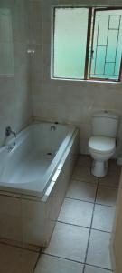 a bathroom with a white tub and a toilet at RestZone Healing Guest Suite in Pietermaritzburg +12 photos