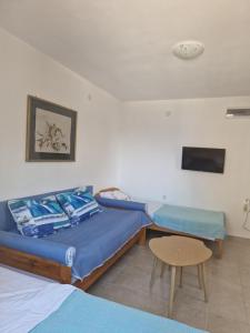 a bedroom with a bed and a table and a tv at Sea view house Zagradje in Bar
