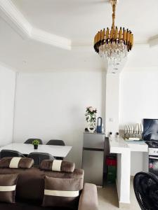 a living room with a table and a chandelier at Maison BA à Ouenzé in Brazzaville