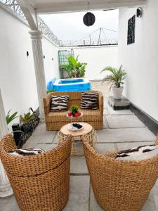 a patio with wicker chairs and a table at Maison BA à Ouenzé in Brazzaville