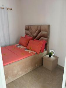a bedroom with a bed with red pillows on it at Maison BA à Ouenzé in Brazzaville