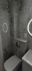 a bathroom with a white toilet and a sink at Apartament Sobieskiego in Puck