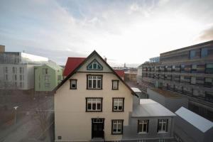 a white house with a red roof in a city at Old Town Reykjavik in Reykjavík