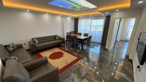 a living room with a couch and a table with chairs at Akçakale Konaklama in Akcaabat