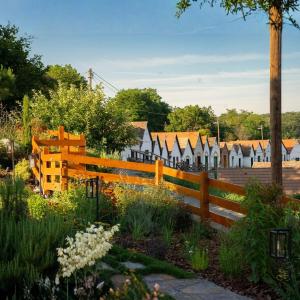 a wooden fence with a row of houses in the background at Hotel Cabernet in Villánykövesd