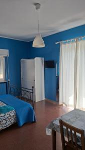 a bedroom with blue walls and a bed and a table at B&B De Angelis in Ginosa Marina