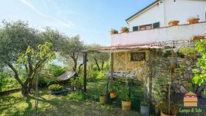 a garden with a house and a swing at In Vino Veritas B&B in Arcola