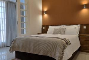 a bedroom with a large bed with a brown headboard at Pérola Suítes Boutique Hotel in Luanda +13 photos
