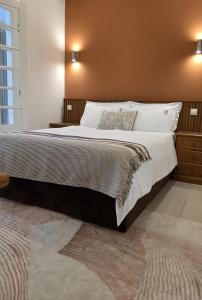 a bedroom with a large bed with a brown wall at Pérola Suítes Boutique Hotel in Luanda