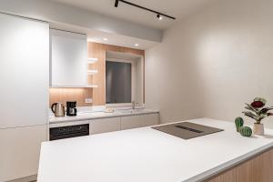 a kitchen with white counters and a white counter top at Aromi Piccolo Hotel in Salò +116 photos