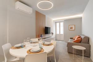 a living room with a white table and a couch at Aromi Piccolo Hotel in Salò