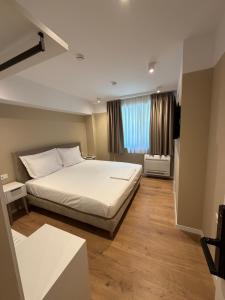 a bedroom with a large white bed and a window at Prime Hotel in Tirana