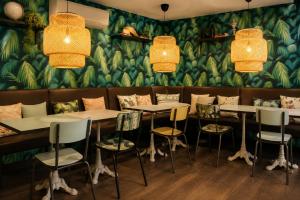 eine Reihe von Tischen und Stühlen in einem Restaurant in der Unterkunft Hotel Alnea in Cannes