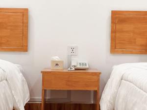 a table with a phone on it next to two beds at Ah Gong Boutique Bungalows in Sihanoukville +4 photos