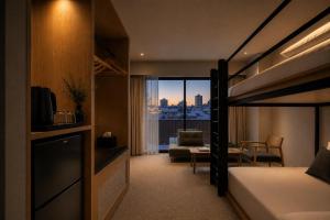 a bedroom with a bunk bed and a living room at Hotel Rima chocolat in Toyohira