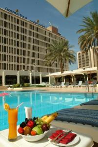 a bowl of fruit on a table in front of a pool at Golden Tulip Bahrain in Manama