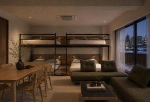 a bedroom with bunk beds and a dining room with a table at Hotel Rima chocolat in Toyohira