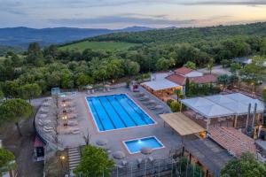 an aerial view of a pool at a resort with mountains in the background at Etrusco Camping Village in Casiano