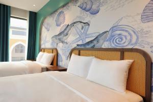 a bedroom with two beds and a wall with a mural at Sonasea Van Don Letavia Hotel in Thâm Câu