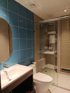 a bathroom with a toilet and a sink and a shower at Sonasea Van Don Letavia Hotel in Thâm Câu