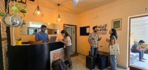 a group of people standing around a counter in a room at Pravaha Hostel in Bangalore