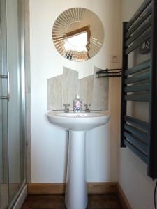 a bathroom with a white sink and a mirror at La Grange des Lavandes in Mérinchal